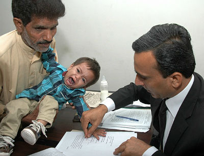  Foto tirada em 3 de abril mostra um policial paquistanês pegando as digitais do bebê Mohammad Musa, que tem nove meses de vida.