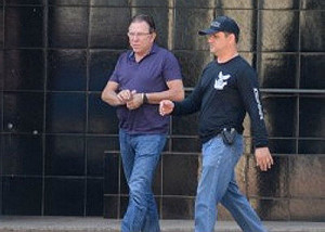 Giroto sendo conduzido pela polícia à sede do Garras (Foto: Bruno Henrique )