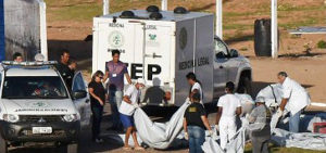 Corpos de presos mortos em rebelião no Rio Grande do Norte são carregados por peritos
